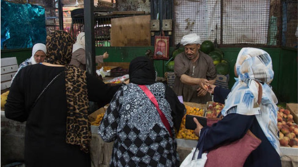 مواطنون مصريون يتسوقون في أحد الأسواق الشعبية في القاهرة.