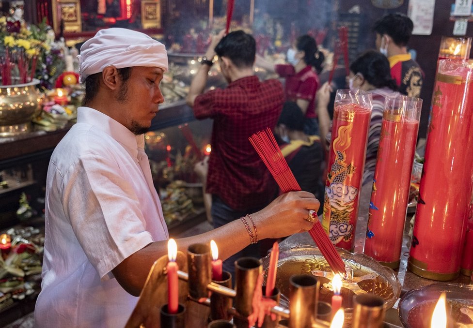 在印度尼西亞巴厘島庫塔，一名男子在一座寺廟舉行的農曆新年慶祝活動中點燃香火。
