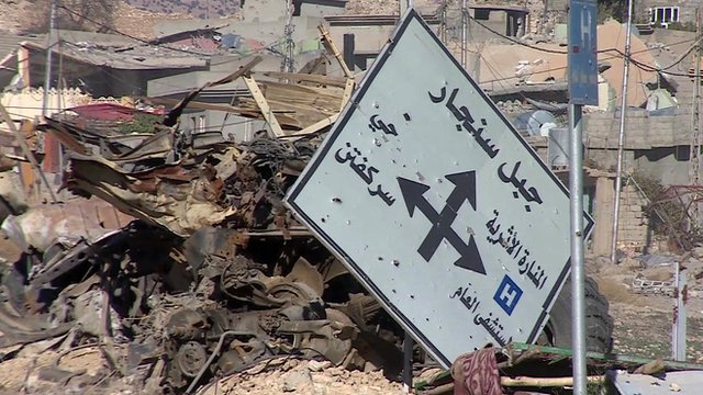 Road sign lies amongst rubble