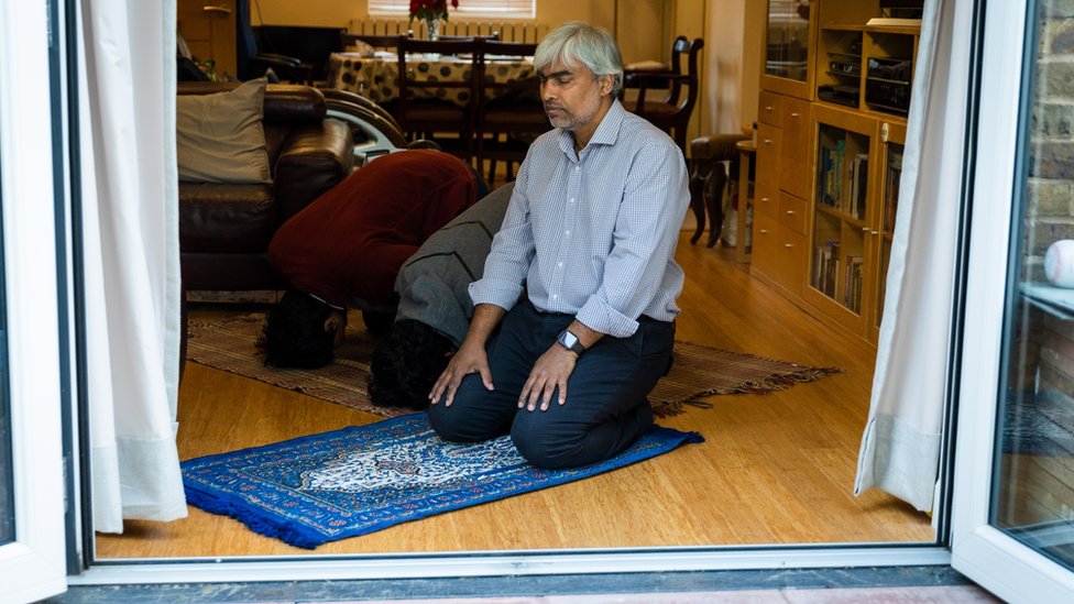 Мисба Ахмед, член мечети Ваппинг, молится на молитвенных ковриках дома со своими двумя сыновьями, 19-летним Мансуром и 17-летним Муширом, во время карантина в связи с коронавирусом в Уаппинге, восточный Лондон