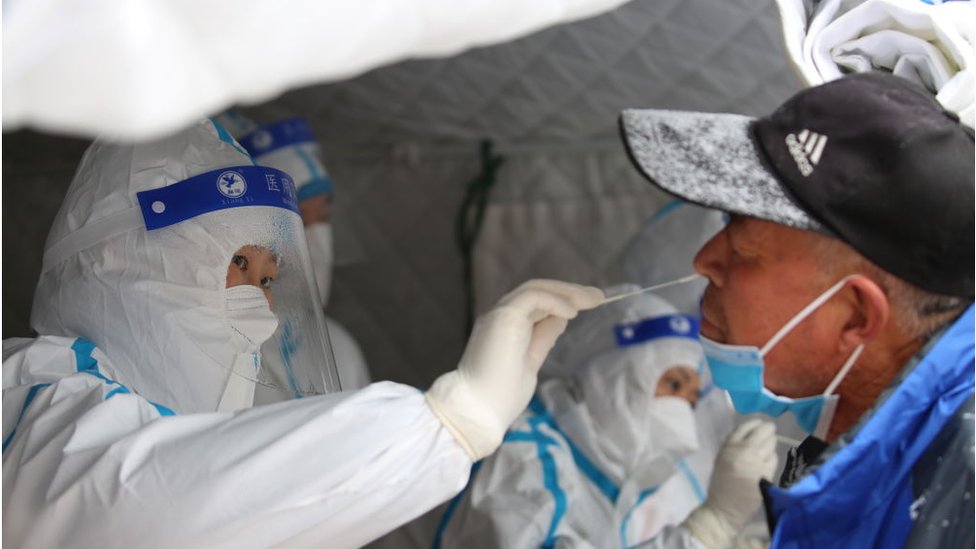 Trabajadores médicos toman muestras de hisopos de los residentes en una prueba masiva de Covid-19 en la nieve en el condado de Shandan, en la provincia noroccidental china de Gansu, el sábado 06 de noviembre de 2021.