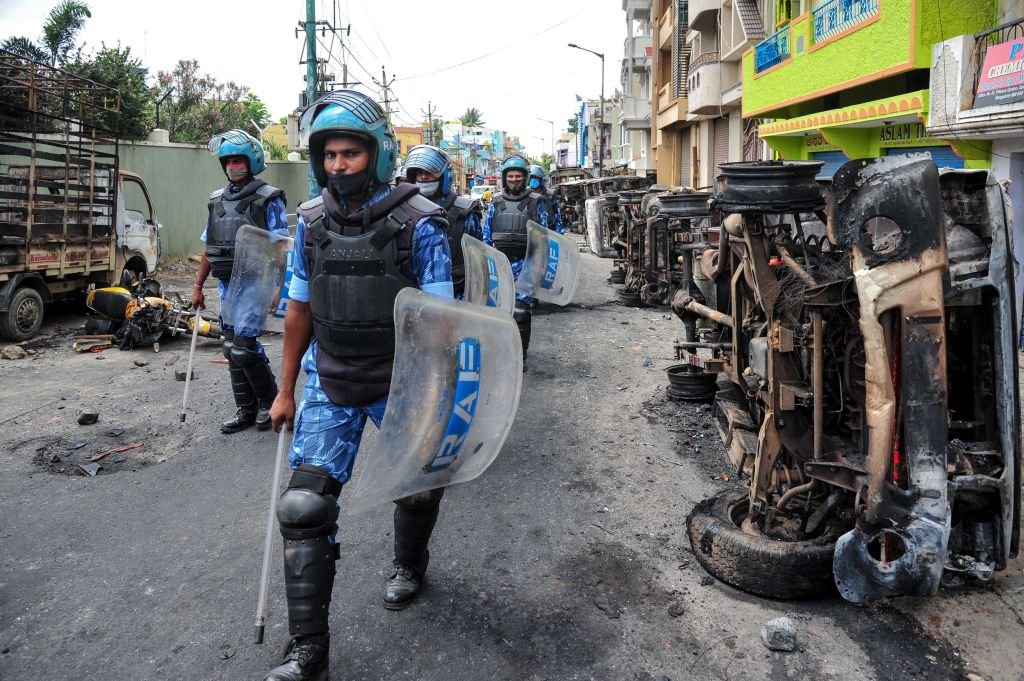 Policías antimotines en Devara Jeevanahalli, India, patrullan la ciudad después de que un mensaje antimusulmán en Facebook desatara violentas protestas