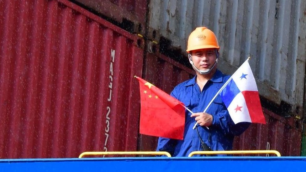 Un operario del Canal de Panamá con la bandera panameña y la china
