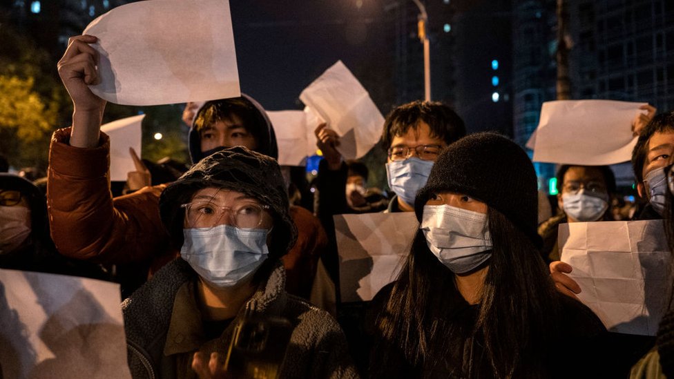 Manifestantes portando hojas en blanco en una manifestación el domingo en Pekín