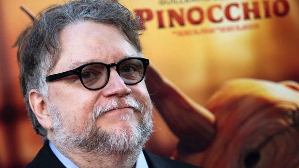 Guillermo del Toro delante de un afiche de "Pinocho".