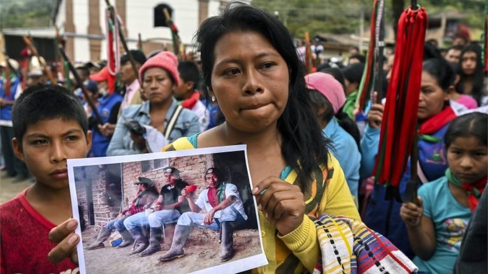Женщина держит фотографию Кевина Местицо (в центре) и Эухенио Тенорио, погибших во время нападения в Торибио