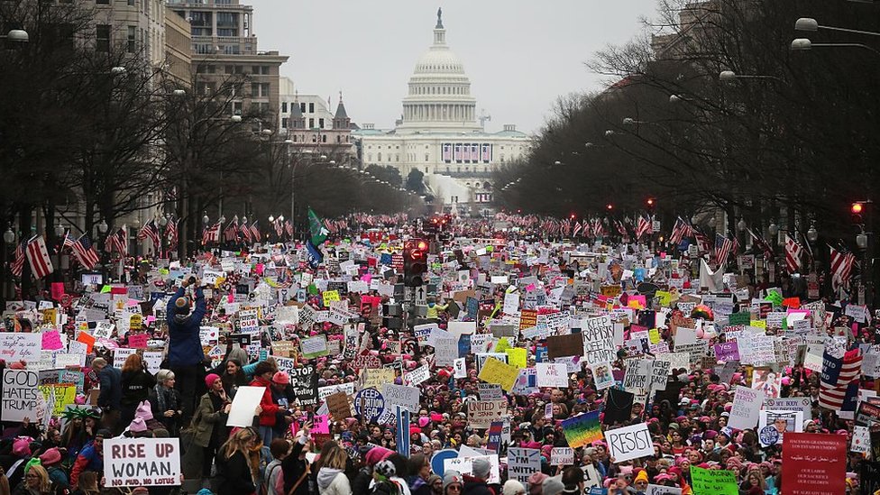 Протестующие идут по Пенсильванской авеню во время Марша женщин в Вашингтоне на фоне Капитолия США 21 января 2017 г.