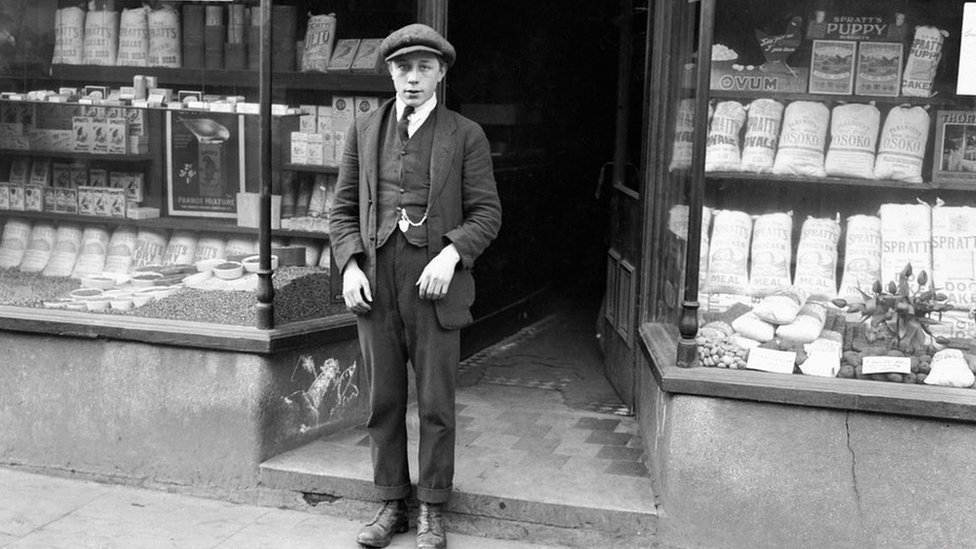 Черно-белое фото Гарольда Джонса возле своего магазина