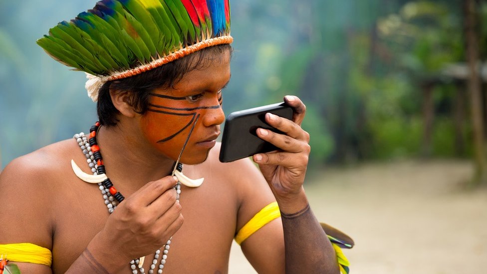 Un hombre indígena de la tribu Tupi Guaraní en Brasil pintándose la cara.