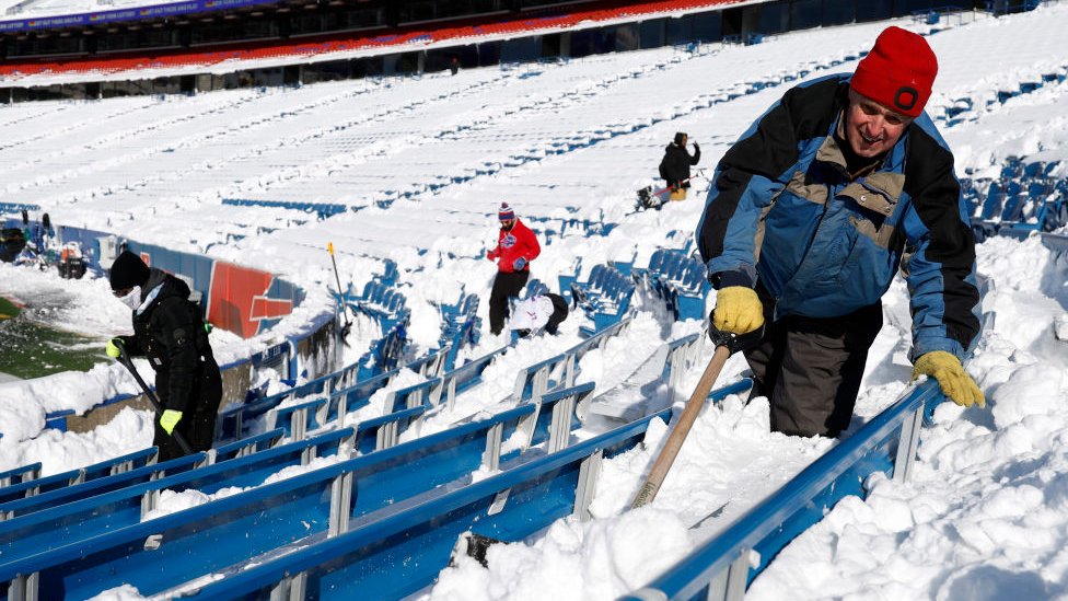 Lokalci pomažeuu čišćenju snega na stadionu Hajmark u Bafalu uoči utakmice plej-ofa