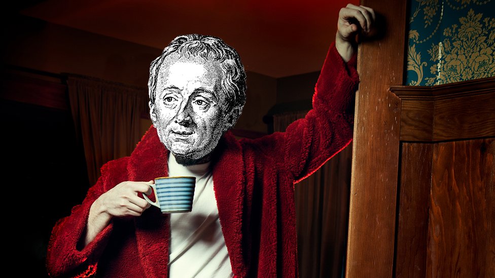 Una simulación de Denis Diderot con una bata roja y taza.