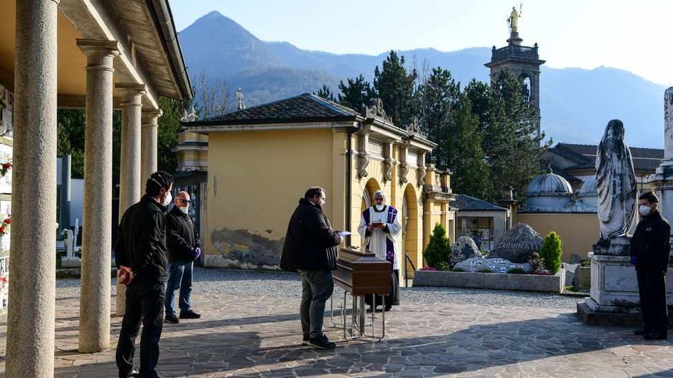 Священник совершает отпевание без родственников на кладбище Зоньо, недалеко от Бергамо, северная Италия, 21 марта 2020 г.