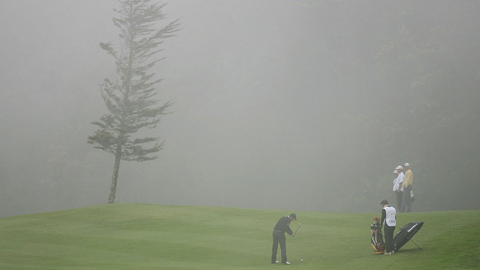 Гольфисты играют в тумане.