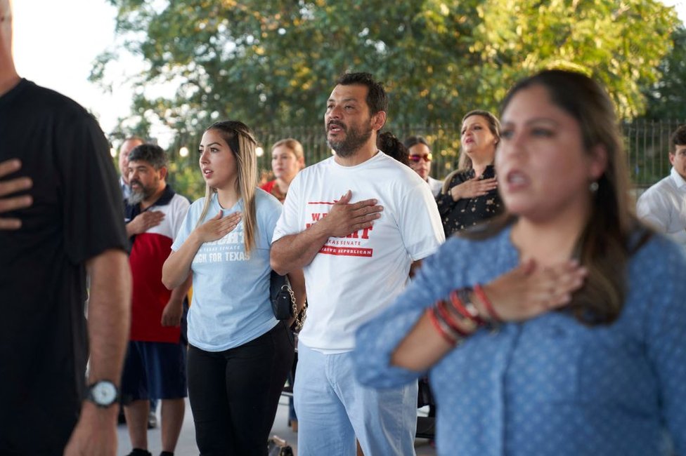 Varios asistentes a un acto de campaña a favor de Monica de la Cruz y Mayra Flores en la Universidad Drafthouse de McAllen, Texas, juran lealtad a la bandera el 10 de octubre de 2022.