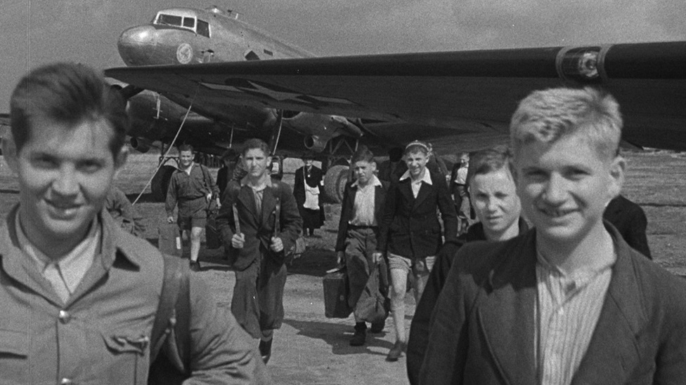 Survivors arriving in the UK with an aeroplane in the background