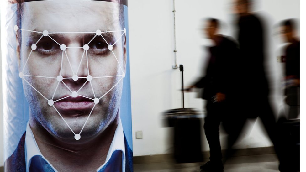 A man walks past a poster simulating facial recognition software at the Security China 2018 exhibition on public safety and security in Beijing.