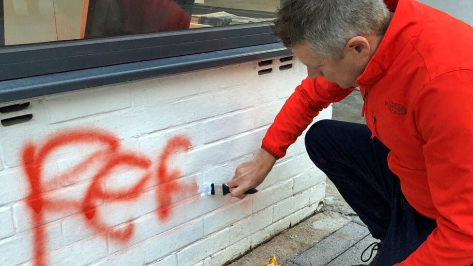 Люк Поллард рисует граффити возле своего офиса
