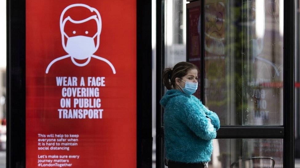 Женщина на автобусной остановке в маске