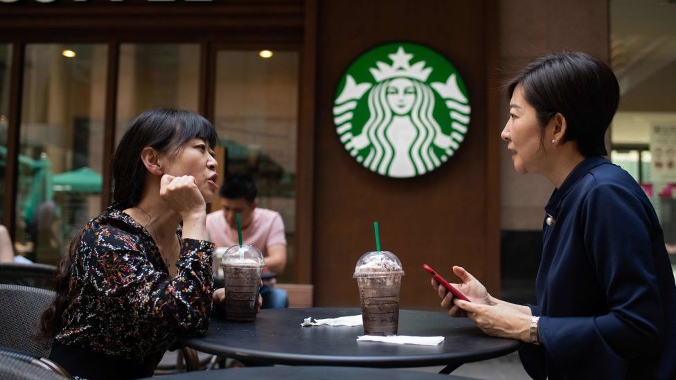 Dos mujeres toman un café en un Starbucks.
