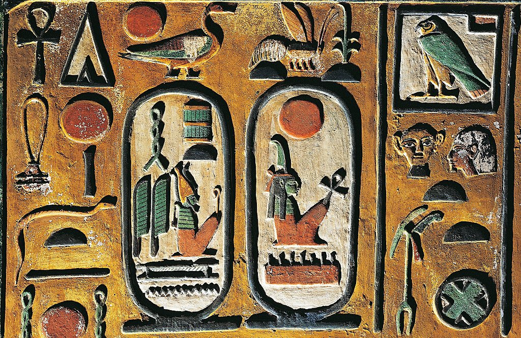 Dos cartuchos en el centro de un tablero con jeroglíficos