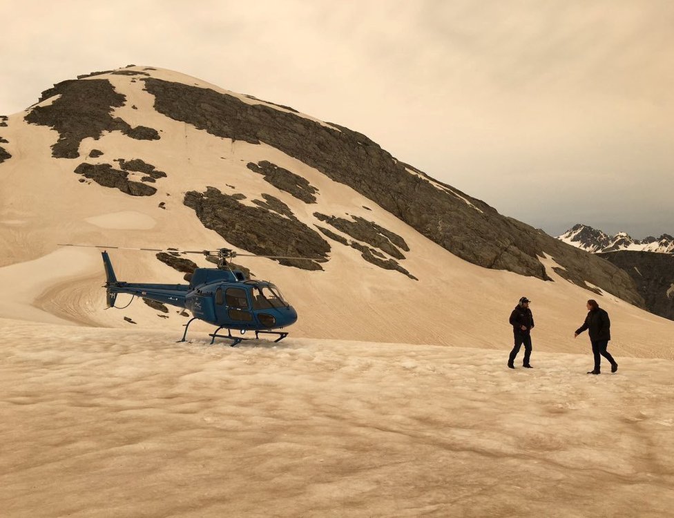 На снегу видны вертолет и два человека