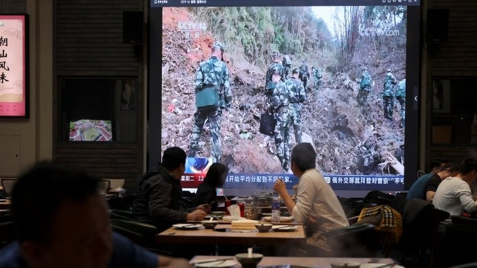 北京某餐館內食客收看大屏幕上播放的東航MU5735客機墜毀報道（22/3/2022）