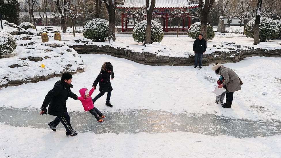 People play in the snow at a Beijing park in February 2011