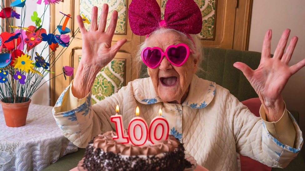 A woman turns 100 years old and celebrates with a cake