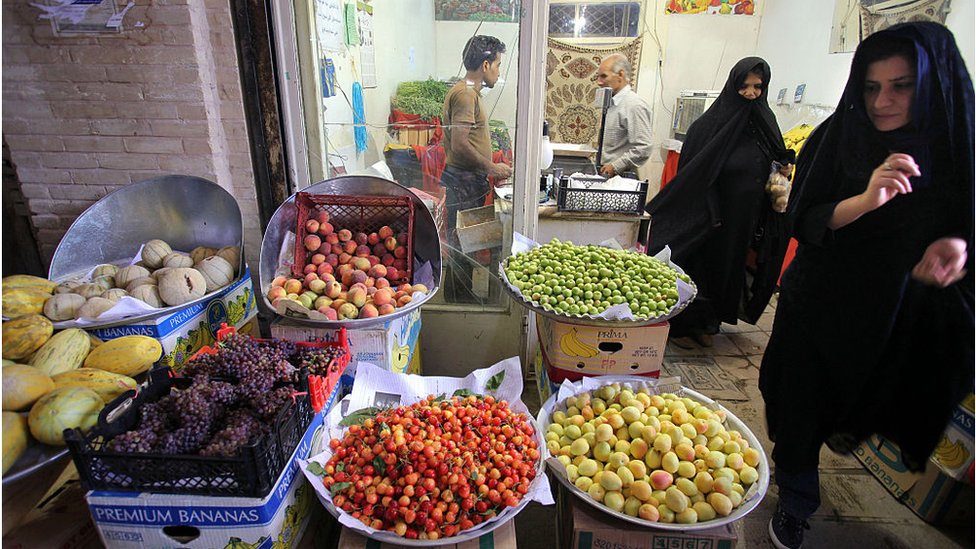 Women walk past fruit for sale in Isfahan (file photo)
