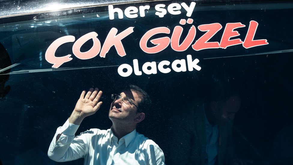 Экрем Имамоглу (К), кандидат в мэры Стамбула от основной оппозиционной Народно-республиканской партии (НРП), машет своим сторонникам