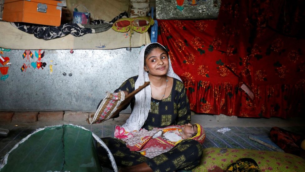 المزارعة واديري التي يبلغ عمرها 17 عاما في منزلها في ضواحي جاكوب آباد تحاول جلب بعض الهواء لطفلها الرضيع خلال موجة الحر