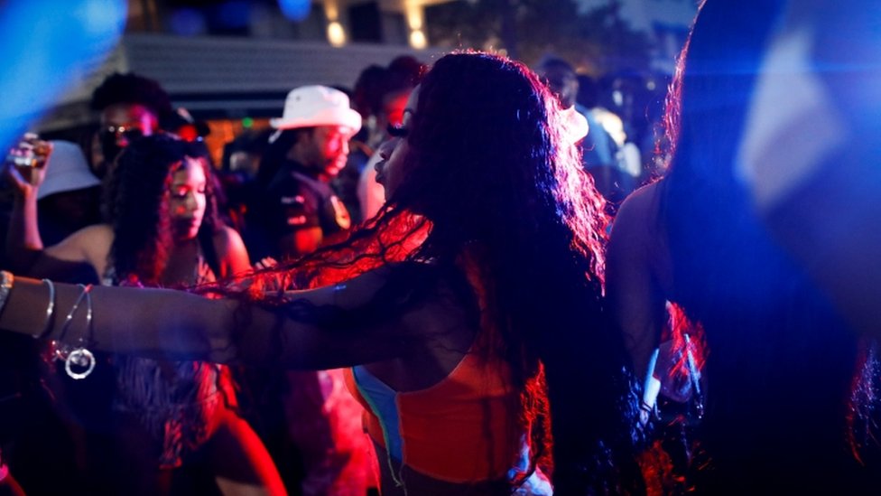 Personas bailando en la calle en Miami Beach.