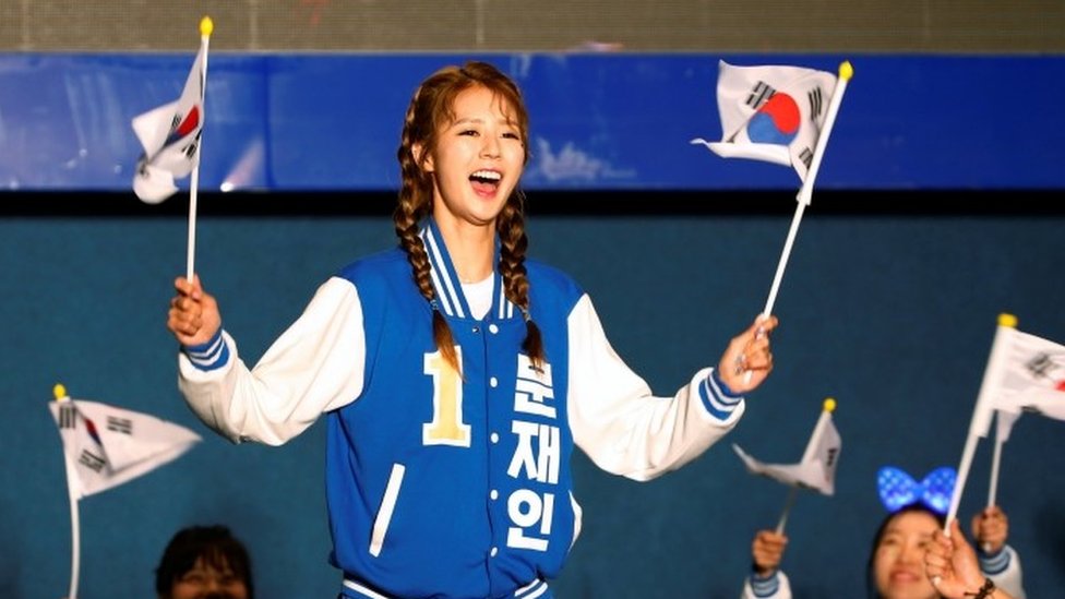 Los seguidores de Moon celebraron al conocer los resultados de las encuestas a boca de urna, que le daban una amplia ventaja a su candidato. Los seguidores del candidato presidencial Moon Jae-in bailan durante la transmisión en la televisión en vivo de los resultados de las encuestas a boca de urna, en Seúl, el 9 de mayo 2017.