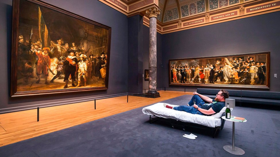 Стефан Каспер лежит в кровати перед картиной голландского художника Рембрандта «Ночной дозор» в Государственном музее Амстердама 1 июня