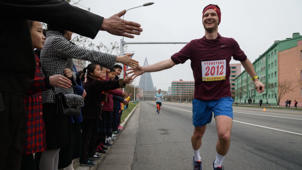 Иностранный бегун дает пять северных корейцев во время марафона