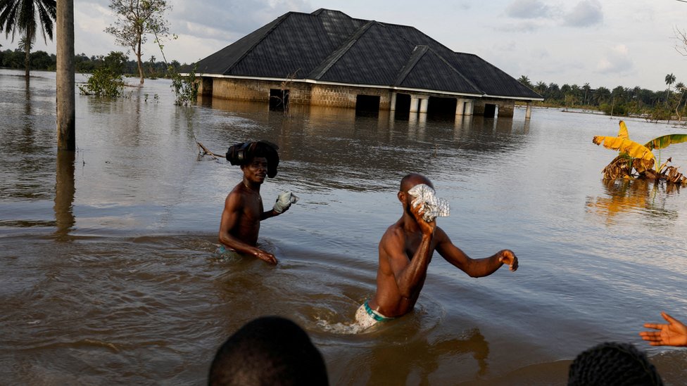 [출처: Reuters] 나이지리아 주민들이 홍수로 불어난 물을 피해 이동하고 있다