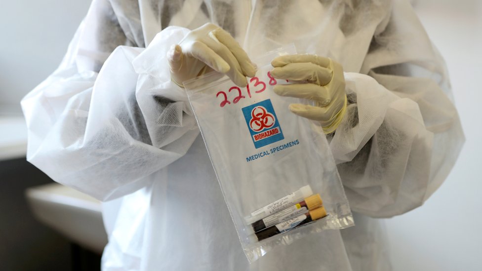 Медицинский работник держит набор для сбора проб вакцины Covid-19 в Йоханнесбурге, Южная Африка