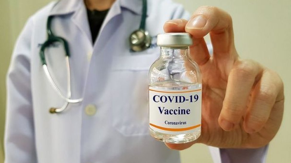 Médico com frasco de vacina contra covid-19