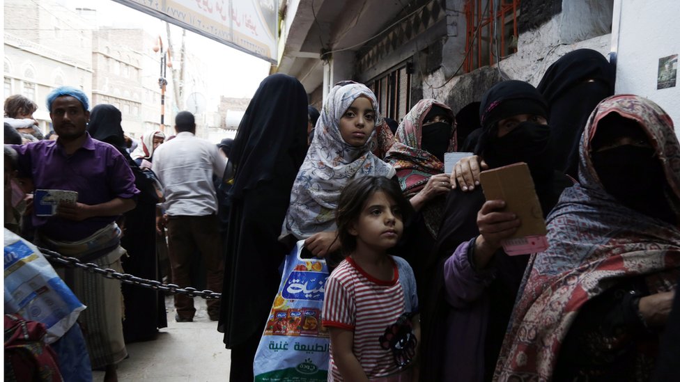 في اليمن الذي أنهكته الحرب نساء وأطفال يصطفون للحصول مساعدات غذائية