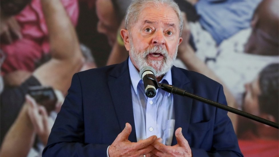 Lula fala ao microfone, em pé