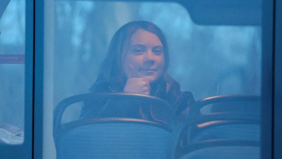 Greta Thunberg gives a thumbs up gesture as she is pictured on a bus