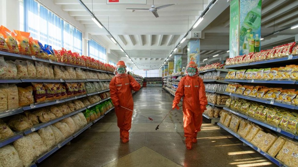 防疫人員在平壤一家超市消毒