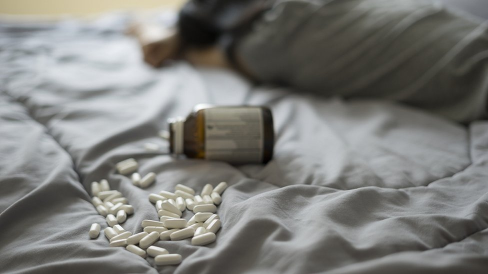 Remédios jogados em uma cama
