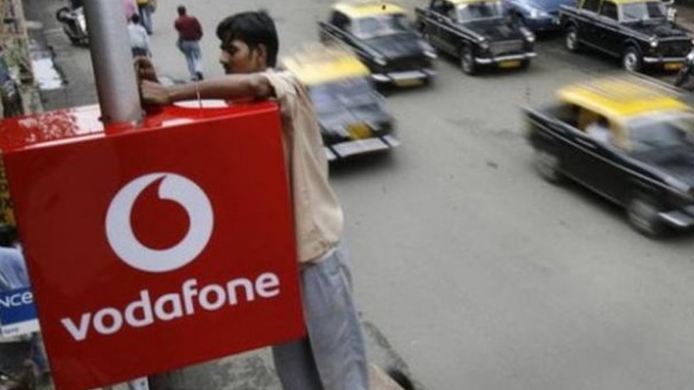 Рабочий настраивает знак Vodafone в Индии