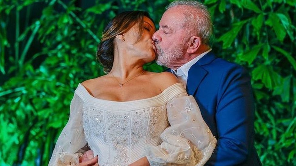 Vestida de novia, Janja besa a Lula, que la abraza por la espalda.