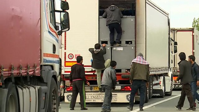 A group of migrants trying to climb into the back of a lorry in Calais