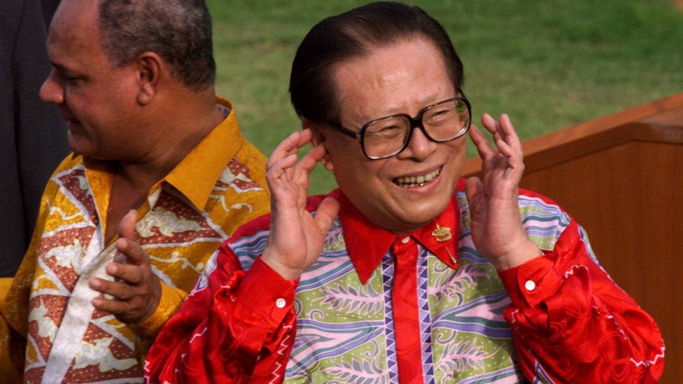 1998年11月18日，亞太經濟合作組織領導人在馬來西亞舉行的峰會結束並發表聲明後，中國國家主席江澤民將手指放在耳邊回應媒體的呼喊。