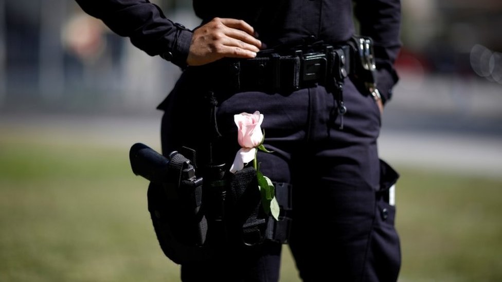 Policía en El Salvador con una rosa en el pantalón