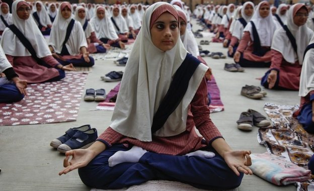 Индийские студенты-мусульмане практикуют йогу в школе в преддверии первого Международного дня йоги в Ахмадабаде, Индия, среда, 17 июня 2015 г.