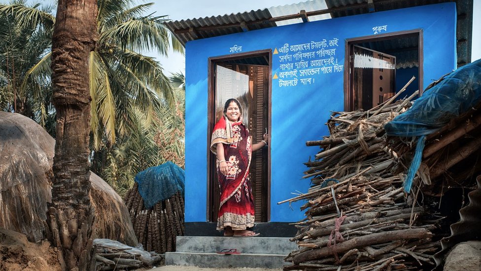 A woman standing outside a new washroom facility in Satkhira district, Bangladesh